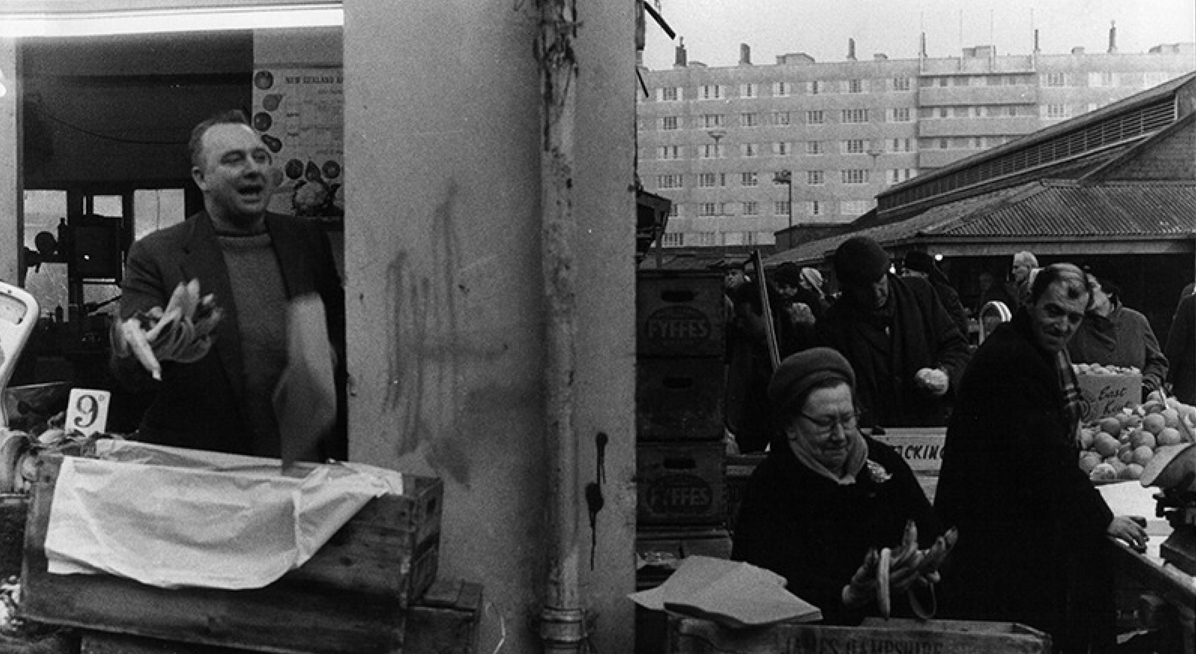 Black and white photograph of people and market stalls 